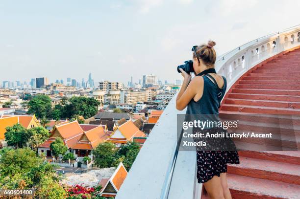 young woman explores city, takes pic from overview - ärmelloses oberteil stock-fotos und bilder