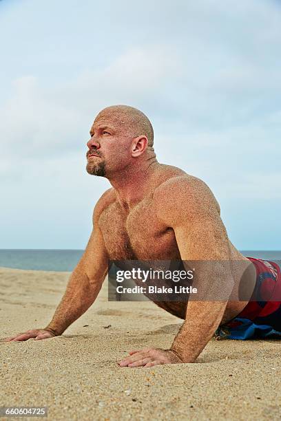 muscular man doing yoga stretch - cream coloured shorts stock pictures, royalty-free photos & images
