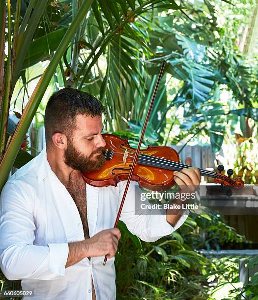 man playing violin in garden - violin stock pictures, royalty-free photos & images