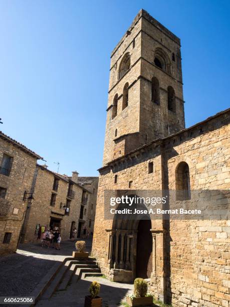 street, gate and tower of the medieval church of santa maría de aínsa - estilos de vida stock pictures, royalty-free photos & images