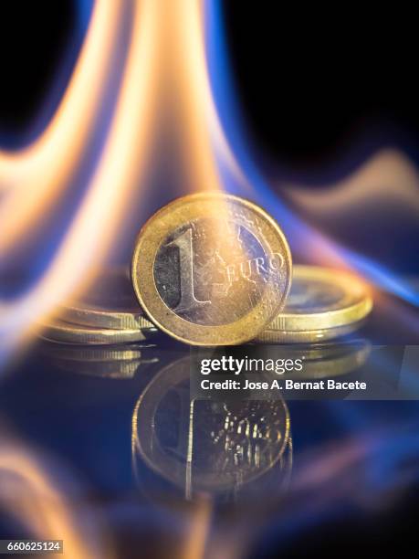 euro coin burned by the fire of the crisis of brexit - actividades bancarias stockfoto's en -beelden