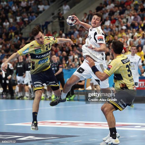 Domagoj Duvnjak of Kiel is challenged by Patrick Groetzki and Alexander Petersson of Rhein-Neckar Loewen during the EHF Champions League Quarter...