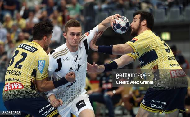 Nikola Bilyk of Kiel is challenged by Alexander Petersson and Gedeon Guardiola of Rhein-Neckar Loewen during the EHF Champions League Quarter Final...