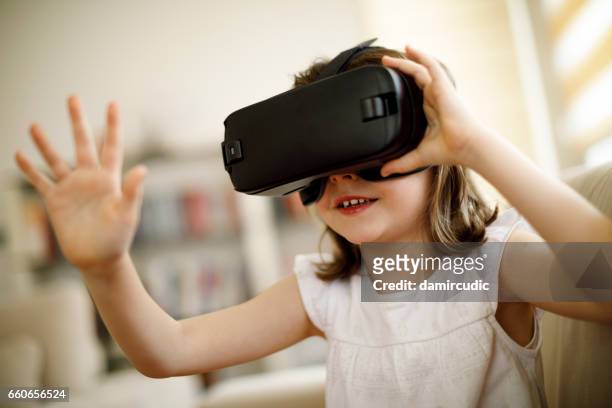kleines mädchen imaginären spiel mit virtual-reality-kopfhörer - human interest stock-fotos und bilder