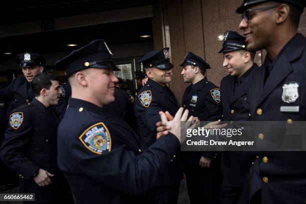 The newest members of the New York City Police Department congratulate each other outside following their police academy graduation ceremony at the...