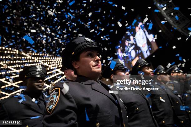 The newest members of the New York City Police Department stand at attention at the conclusion of their police academy graduation ceremony at the...