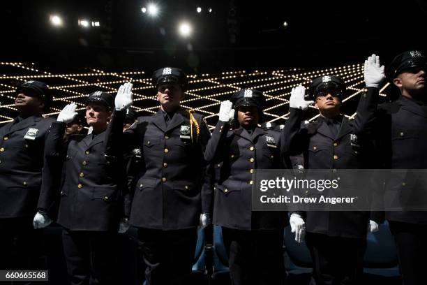 The newest members of the New York City Police Department are sworn-in during their police academy graduation ceremony at the Theater at Madison...