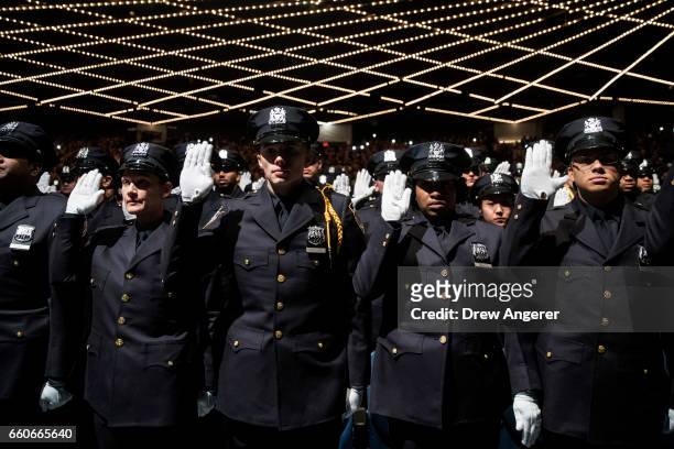 The newest members of the New York City Police Department are sworn-in during their police academy graduation ceremony at the Theater at Madison...