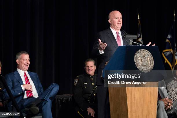 New York City Mayor Bill De Blasio looks on as New York City Police Commissioner James O'Neill delivers remarks during a police academy graduation...