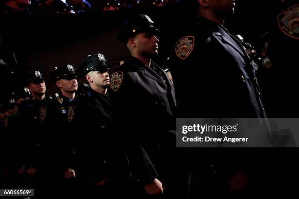 The newest members of the New York City Police Department prepare to exit at the conclusion of their police academy graduation ceremony at the...