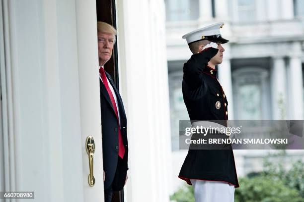 President Donald Trump waits to greet Denmark's Prime Minister Lars Lokke Rasmussen outside the West Wing of the White House before a meeting on...