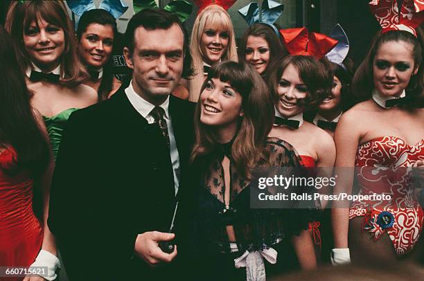 American publisher and club owner, Hugh Hefner pictured with his girlfriend Barbi Benton and various bunny girls during a visit to his London Playboy...