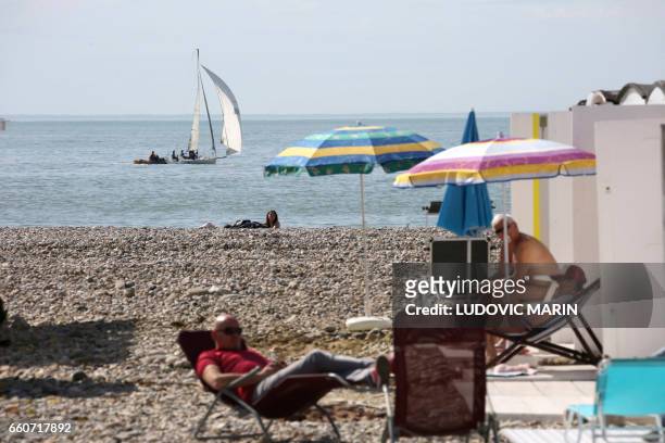 People enjoy a sunny day on the beach of Le Havre, on the Normandy coast on March 30, 2017.