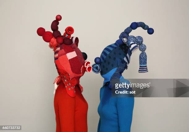 two women wearing mask made of blue and red socks kissing,side view - funny mask stock-fotos und bilder