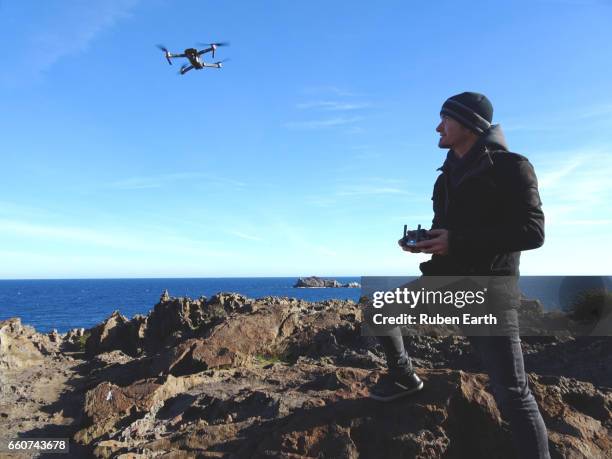 man flying a drone - drone pilot stock pictures, royalty-free photos & images