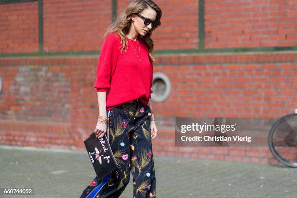 Model and fashion blogger Alexandra Lapp wearing a black and multicoloured floral print trousers from Fendi featuring a high rise, a concealed front...