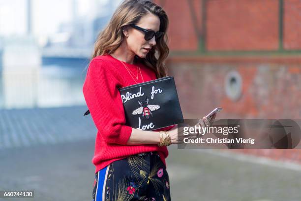 Model and fashion blogger Alexandra Lapp wearing a black and multicoloured floral print trousers from Fendi featuring a high rise, a concealed front...