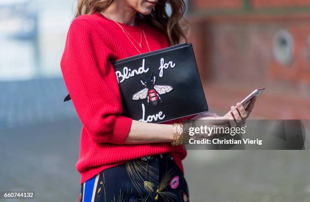 Model and fashion blogger Alexandra Lapp wearing a black and multicoloured floral print trousers from Fendi featuring a high rise, a concealed front...