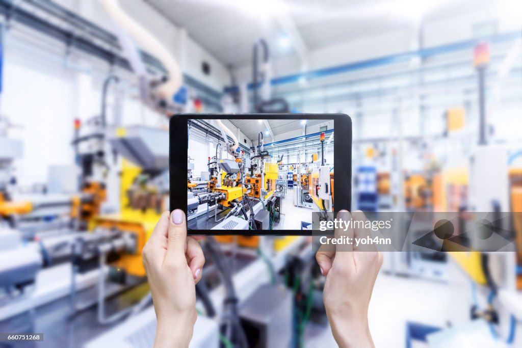 Digital-Tablette & futuristische Industriemaschinen