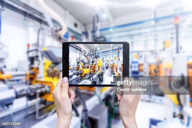 digital-tablette & futuristische industriemaschinen - automation industrie stock-fotos und bilder