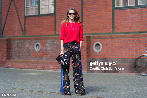 Model and fashion blogger Alexandra Lapp wearing a black and multicoloured floral print trousers from Fendi featuring a high rise, a concealed front...