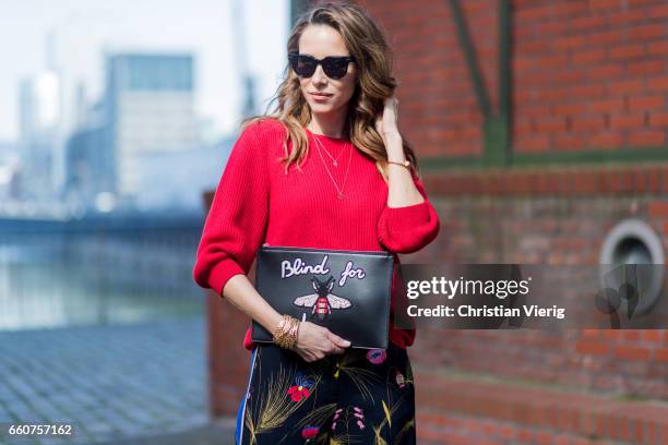 Model and fashion blogger Alexandra Lapp wearing a black and multicoloured floral print trousers from Fendi featuring a high rise, a concealed front...