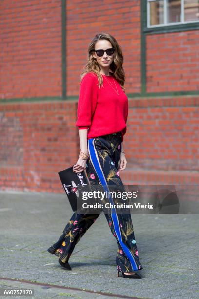 Model and fashion blogger Alexandra Lapp wearing a black and multicoloured floral print trousers from Fendi featuring a high rise, a concealed front...