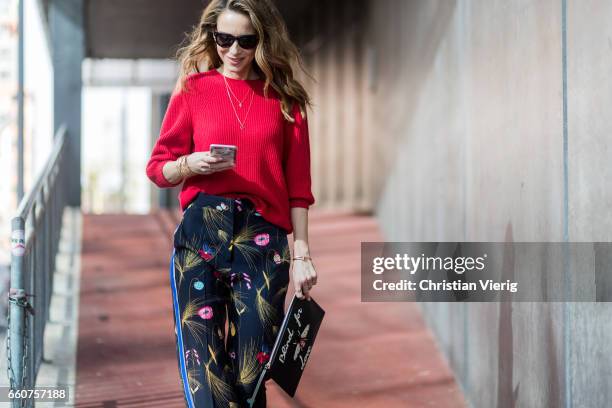 Model and fashion blogger Alexandra Lapp wearing a black and multicoloured floral print trousers from Fendi featuring a high rise, a concealed front...