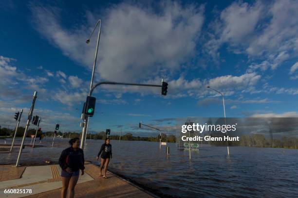 Local residents Christie and Haleigh McIntyre watches on as the Logan River near Beaudesert floods surrounding areas on March 31, 2017 in Brisbane,...