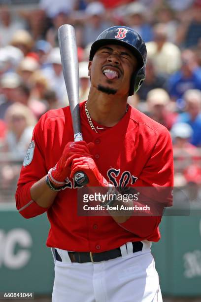 Mookie Betts of the Boston Red Sox reacts after being hit in the back by a pitched ball by the Washington Nationals during a spring training game at...
