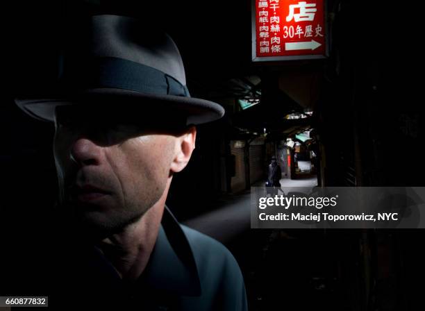 portrait of a man in hat in chinatown. - action movie stock pictures, royalty-free photos & images