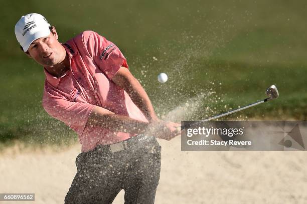 Robert Streb hits his third shot from a greenside bunker on the 18th hole during the first round of the Shell Houston Open at the Golf Club of...