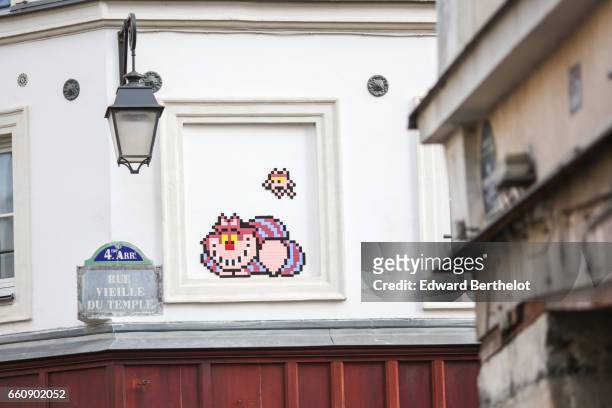 Piece of street art, showing a Cat - Cheshire Cat of Disney's Alice in Wonderland - is seen in Rue Vieille du Temple, in the 4th quarter of Paris, on...
