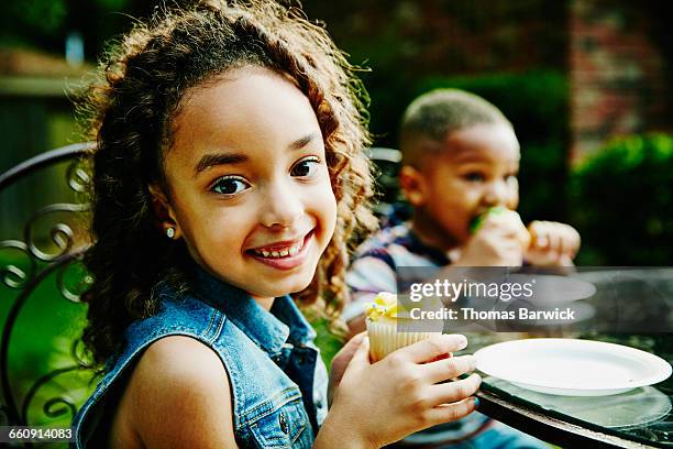 smiling young girl holding cupcake at party - paper plate 個照片及圖片檔