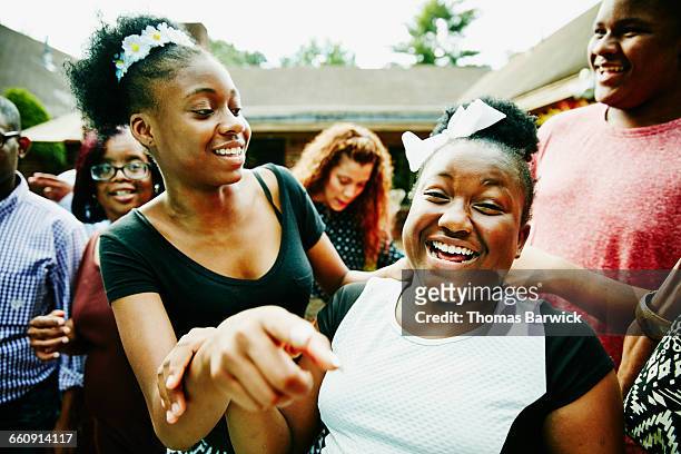 laughing sisters at backyard family party - black girls fotografías e imágenes de stock