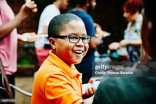 laughing boy playing cards with family and friends - simple living stock pictures, royalty-free photos & images