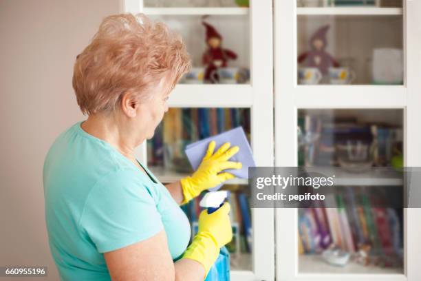 senior woman cleaning at home - yellow washing up glove stock pictures, royalty-free photos & images