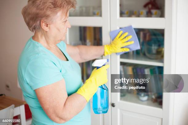 senior woman cleaning at home - yellow washing up glove stock pictures, royalty-free photos & images