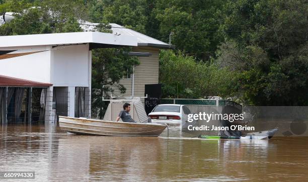 Residents use a boat on March 31, 2017 in South Murwillumbah, Australia. Heavy rain has caused flash flooding in south east Queensland and Northern...