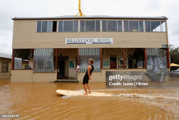 Local residents surf down the main street on March 31, 2017 in Billinudgel, Australia. Heavy rain has caused flash flooding in south east Queensland...