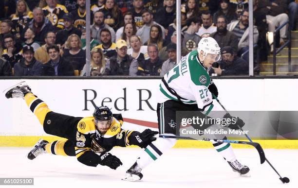 Adam McQuaid of the Boston Bruins dives to defend Adam Cracknell of the Dallas Stars during the second period at TD Garden on March 30, 2017 in...