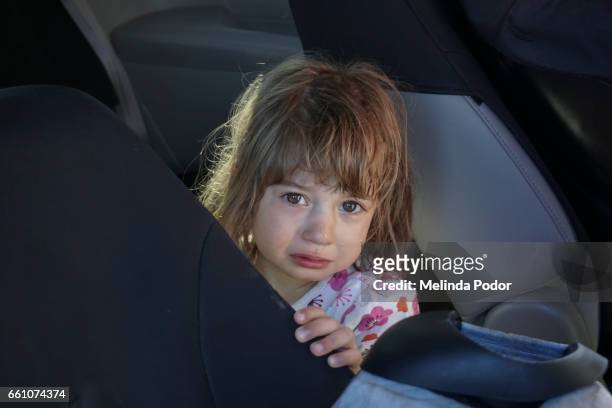 crying child inside a mini van, looking at camera - child crying stock-fotos und bilder