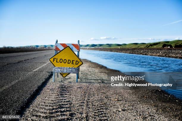 flooded sign and road - california flooding stockfoto's en -beelden