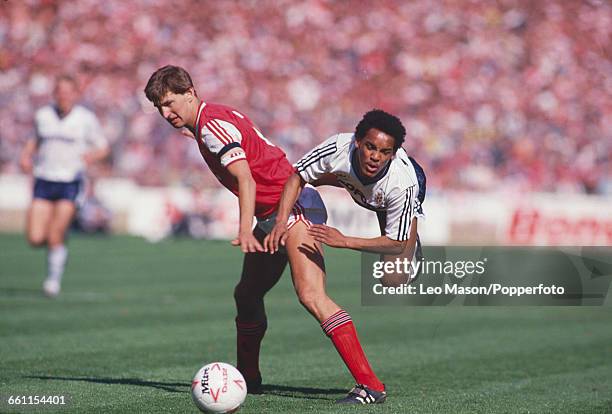 English footballer and captain of Arsenal, Tony Adams shields the ball from Luton Town player Mark Stein during the 1988 Football League Cup Final...