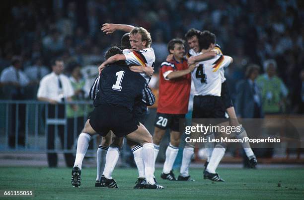 German footballer Andreas Brehme celebrates with goalkeeper Bodo Illgner as Jurgen Kohler hugs Lothar Matthaus and substitute Olaf Thon after West...