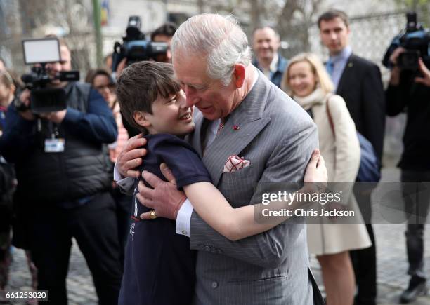 Prince Charles, Prince of Wales receives a hug from Valentin Blacker, son of William Blacker who is a local conservationist during a walking tour of...