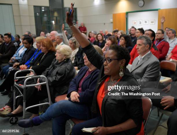 Alice Brown raises her hand to ask a question at a community meeting about the recent spate of gang-related violence in Fairfax County held at the...