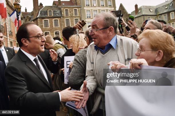 French President Francois Hollande , next to Boulogne-sur-Mer Mayor and MP Frederic Cuvillier , shakes hands with people as he leaves the city hall...