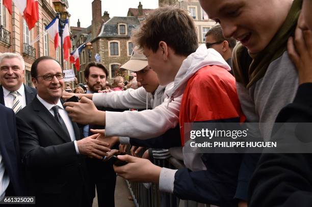 French President Francois Hollande , next to Boulogne-sur-Mer Mayor and MP Frederic Cuvillier , shakes hands with people as he leaves the city hall...