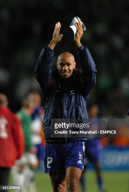 France's Thierry Henry smiles to the French fans at the end of the match